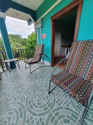 two chairs sitting on a porch with a tile floor at River Park Inn in San Ignacio