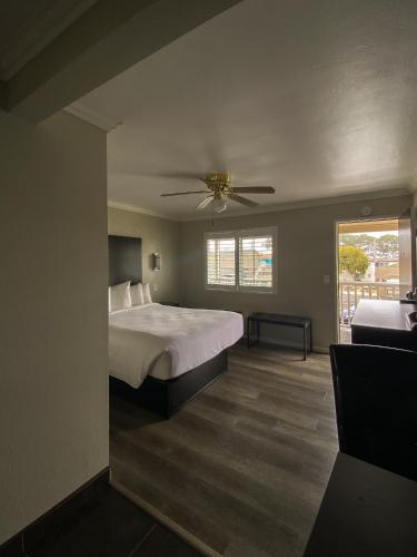 a bedroom with a bed and a ceiling fan at Rockview Inn and Suites in Morro Bay