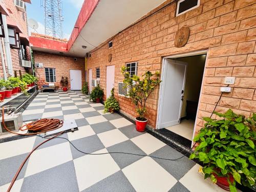 a courtyard of a brick building with a door and plants at Liliyan Palace Guest house in Jodhpur
