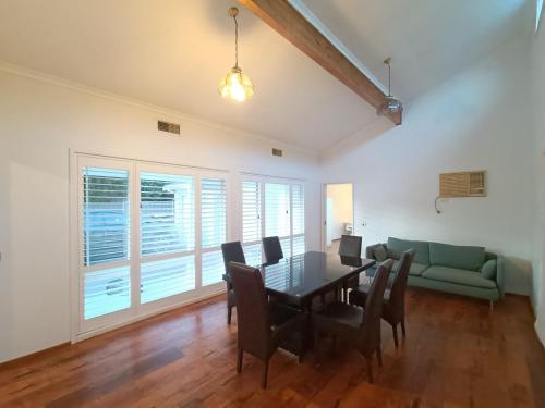 a dining room with a table and a green couch at Peaceful Room in Modern Baulkham Hills Home - BH3 in Baulkham Hills
