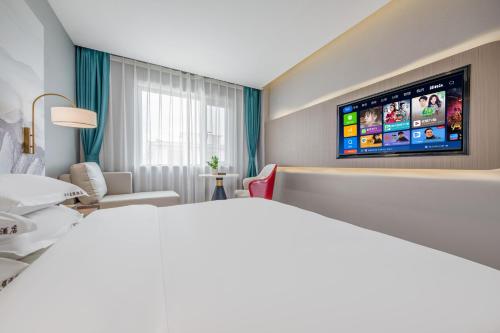 a hotel room with a bed and a flat screen tv at 丽江古城丽漫酒店 in Lijiang