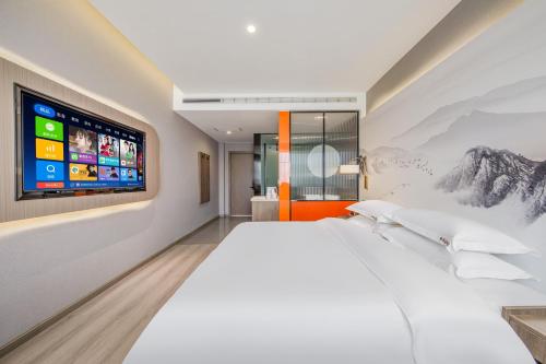 a bedroom with a large bed and a tv on the wall at 丽江古城丽漫酒店 in Lijiang