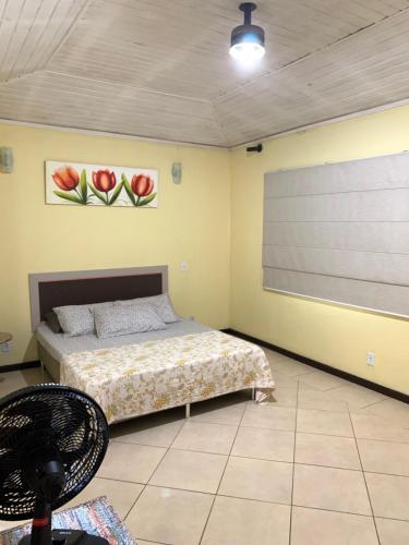 une chambre avec un lit et un écran de projection dans l'établissement Casa confortável e espaçosa em Búzios, à Armacao dos Buzios