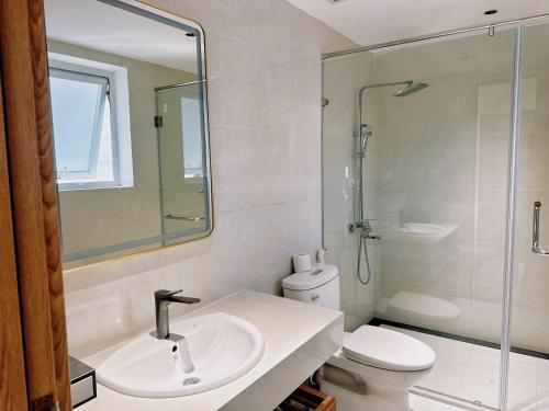 a bathroom with a sink and a toilet and a shower at NGAN HA HOTEL in Ðại Tiêt