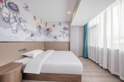 a bedroom with a bed and a painting on the wall at 丽江古城丽漫酒店 in Lijiang