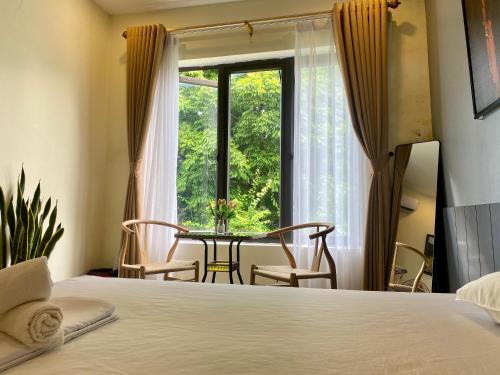 a bedroom with a bed and a table and a window at Tam Coc Phuong Nhi Homestay in Ninh Binh