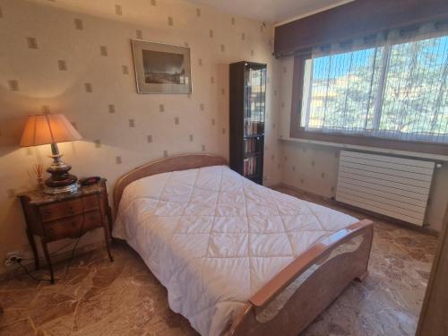 une chambre avec un lit, une lampe et une fenêtre dans l'établissement Beau 2 pièces climatisé avec terrasse et piscine, proche centre Sainte-Maxime - FR-1-780-85, à Sainte-Maxime