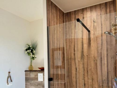 e bagno con doccia e parete in legno. di Chambre cosy avec salle d'eau, accès piscine chauffée et Wi-Fi illimité - FR-1-591-620 a Faverolles