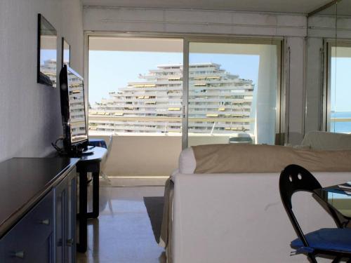 Cette chambre comprend un lit et offre une vue sur un bâtiment. dans l'établissement Appartement vue mer avec parking, Villeneuve-Loubet - FR-1-252A-130, à Villeneuve-Loubet