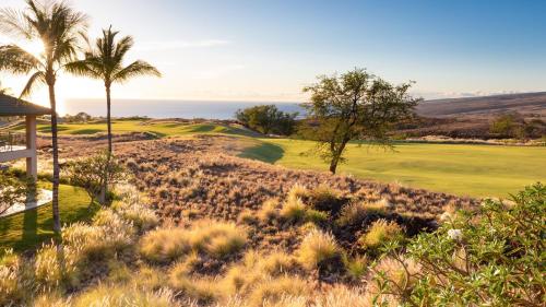 a golf course with palm trees and a green at ❤PiH❤ Endless Ocean Views Villa Gorgeous Mauna Kea Ocean and Mountain View in Hapuna Beach