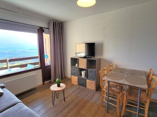 un salon avec une table à manger et une télévision dans l'établissement Studio cosy 2 pers au pied des pistes - FR-1-393-176, à Saint-Michel-de-Chaillol