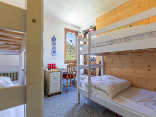 une chambre avec deux lits superposés et un bureau dans l'établissement Charmant 3 pièces 6 pers, terrasse 40m², parking couvert - FR-1-404-353, à La Mongie