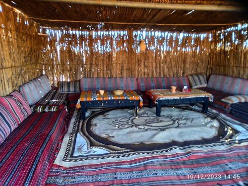 a living room with a couch and a table at Desert Private Camp - Bedouin Camp in Al Wāşil