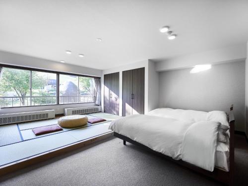a bedroom with a large bed and a large window at Hakuba Alps Hotel in Otari