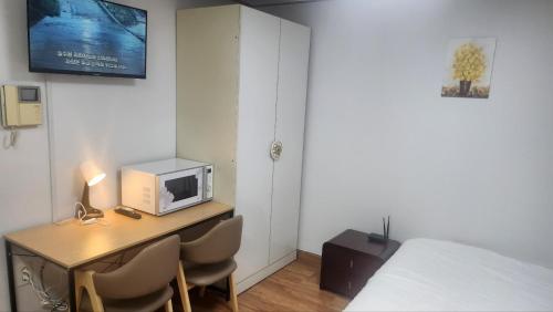 a room with a desk with a microwave and a bed at Kiman09 in Seoul