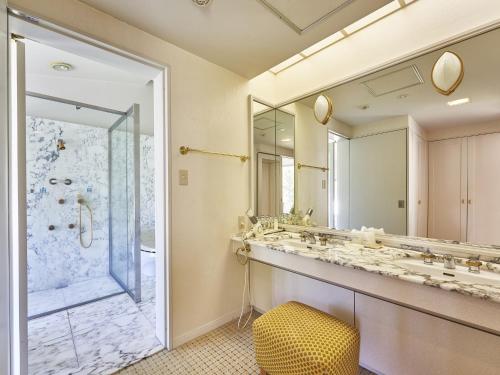 a bathroom with a large mirror and a sink at Hakuba Alps Hotel in Otari