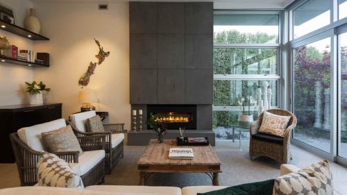 a living room with a couch and a fireplace at Supreme Lakefront by MajorDomo in Frankton Wharf