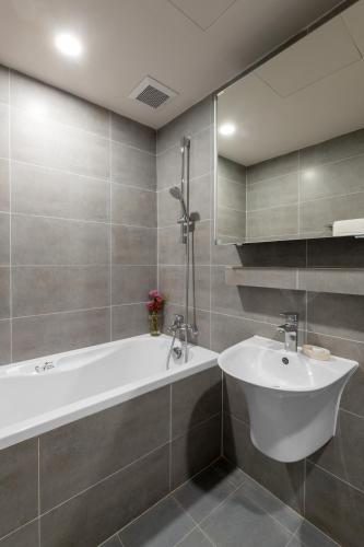 a bathroom with a bath tub and a sink at Sunflower International Village in Hai Phong
