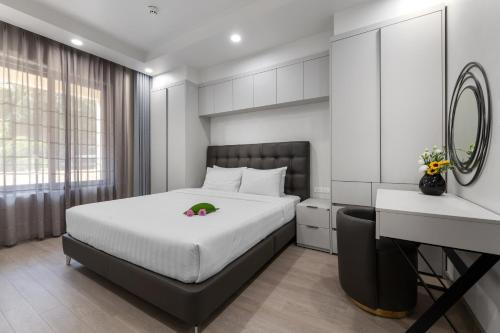 a bedroom with a bed and a desk and a mirror at Sunflower International Village in Hai Phong