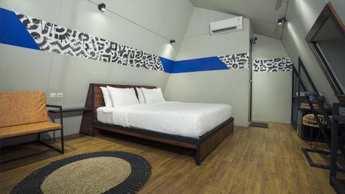 a bedroom with a white bed and a blue and white wall at Villa Marcolina 57 in Gadok 1