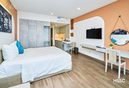 a bedroom with a bed and a desk and a tv at Ohana Village in Phương Phi