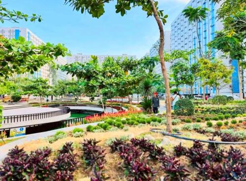 a park in the city with trees and flowers at Pandora's Nest in Manila