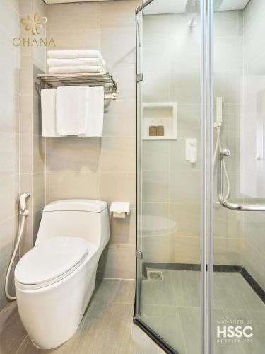 a bathroom with a toilet and a glass shower at Ohana Village in Phương Phi