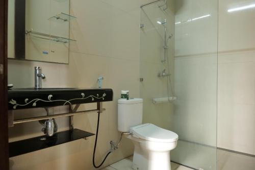 a bathroom with a toilet and a sink and a shower at Villa Marcolina 57 in Gadok 1