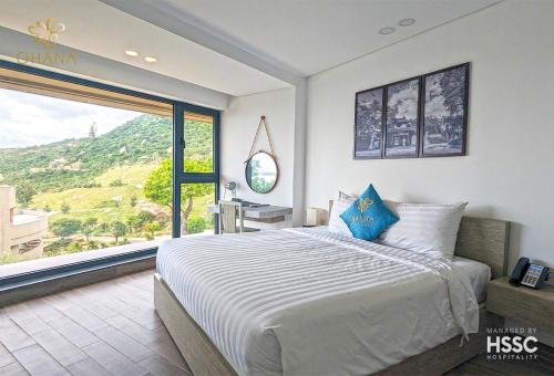 a bedroom with a large bed and a large window at Ohana Village in Phương Phi