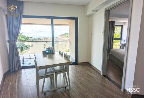 a room with a table and a view of a bedroom at Ohana Village in Phương Phi