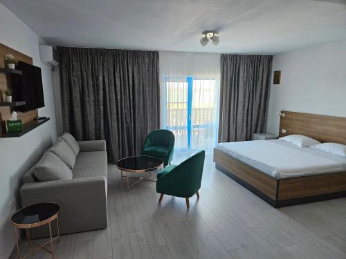 a hotel room with a bed and a couch at Pensiunea Aventurin in Murighiol