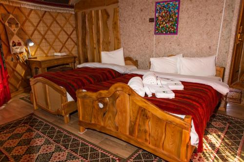 a bedroom with a large wooden bed with towels on it at Supara Chunkurchak in Alamedin