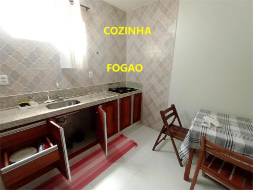 a small kitchen with a sink and a table at Pousada Lagoa Flat in Morro de São Paulo