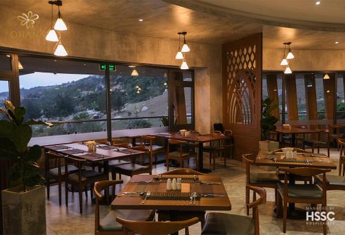 a restaurant with tables and chairs and a large window at Ohana Village in Phương Phi