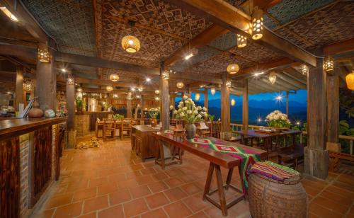 a restaurant with tables and chairs and a bar at Puluong Valley Home in Pu Luong