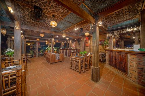 a restaurant with tables and chairs and a bar at Puluong Valley Home in Pu Luong