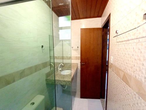 a bathroom with a sink and a glass shower at Pousada Lagoa Flat in Morro de São Paulo