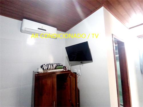 a room with a tv on a wall at Pousada Lagoa Flat in Morro de São Paulo