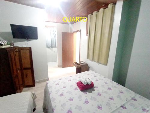 a bedroom with a bed with a red object on it at Pousada Lagoa Flat in Morro de São Paulo
