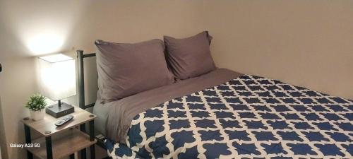 a bedroom with a bed with a blue and white comforter at HomeStay in Boston - Dorchester Fields Corner Area in Boston
