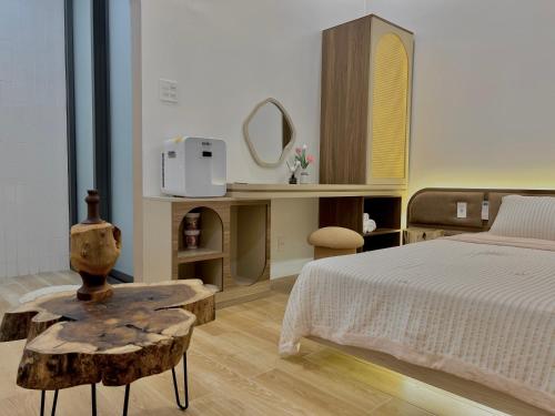 a bedroom with a bed and a table and a mirror at Homestay Lucie đảo Phú Quý in Cu Lao Thu
