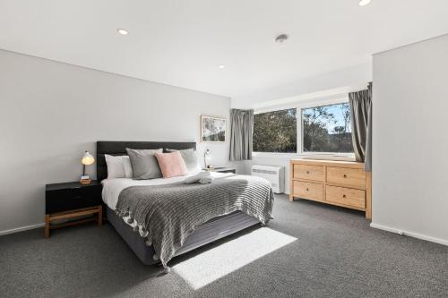 a bedroom with a large bed and a window at Silvertop Chalet in Crackenback