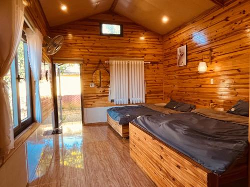 a bedroom with two beds in a log cabin at Gia Huan Homestay - Tà Đùng in Biđong