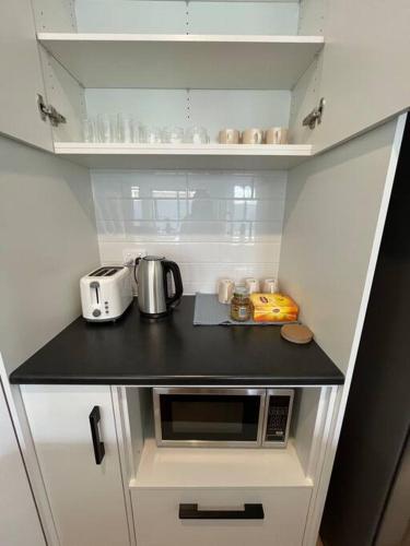a small kitchen with a counter with a microwave at Sturt Home near FMC & Flinders Uni in Sturt