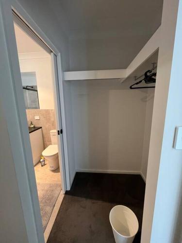 a bathroom with a toilet and a door to a room at Sturt Home near FMC & Flinders Uni in Sturt