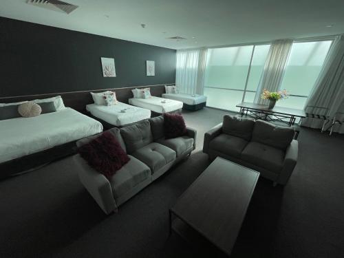 a living room with a couch and couches and a table at Sfera's Park Suites & Convention Centre in Adelaide