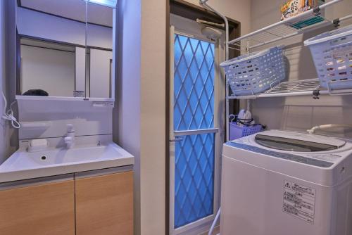 a bathroom with a sink and a washing machine at Near Osaka Castle entire villa at Kyobashi Station in Osaka