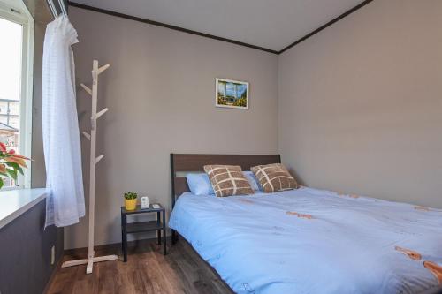 a bedroom with a bed with blue sheets and pillows at Near Osaka Castle entire villa at Kyobashi Station in Osaka