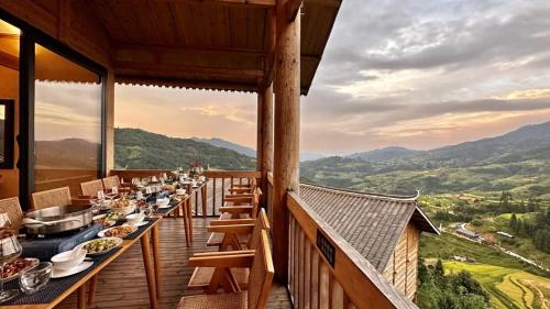 a restaurant with tables and chairs on a balcony at The Well House in Jiayi