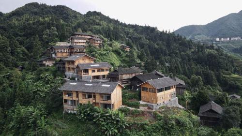a group of houses on the side of a mountain at The Well House in Jiayi